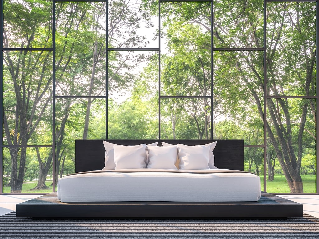 Modern bedroom with garden view 3d rendering Image.There are large window overlooking the surrounding garden and nature